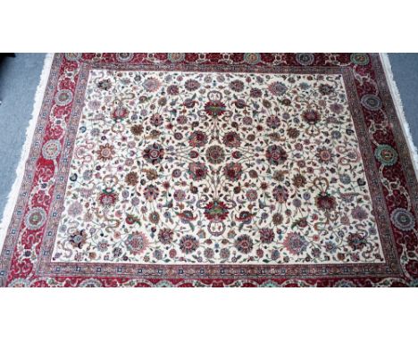 A Tabriz Shah Abass carpet, Persian, the ivory field with an allover design of palmettes and trailing floral sprays; a madder