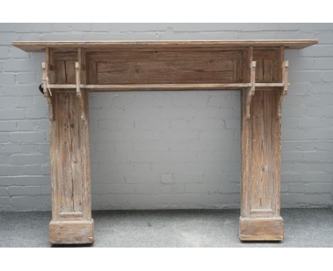 An Arts and Crafts pine fire surround with twin ledge mantel, 168cm wide x 119cm high, aperture 91cm wide x 91cm high. 