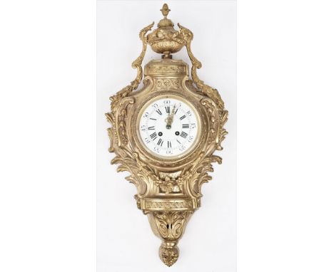 An 18th century style gilt metal cartel clock, 20th century with urn finial over a foliate cast case and white enamel dial en