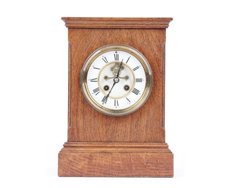 An Edwardian oak cased mantel clock with visible brocot escapement, and a French two train movement with hammer striking a co