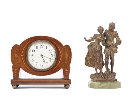 An Art Nouveau style mahogany and inlaid mantel clock, early 20th century, of unusual outline, 17cm high, and gilt metal figu