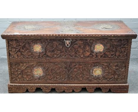 A 19th century Indian brass and copper mounted, carved hardwood trunk with shaped plinth, 105cm wide x 53cm high. 