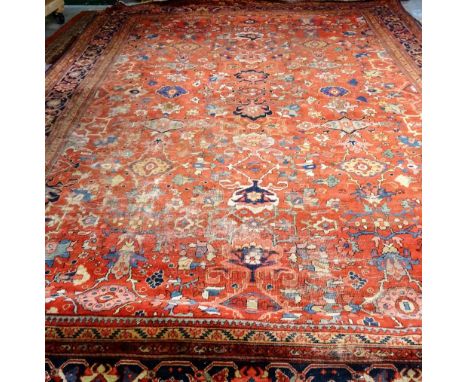 A Mahal carpet, Persian, the madder field with an allover design of bold flowerheads, palmettes and connecting floral sprays;