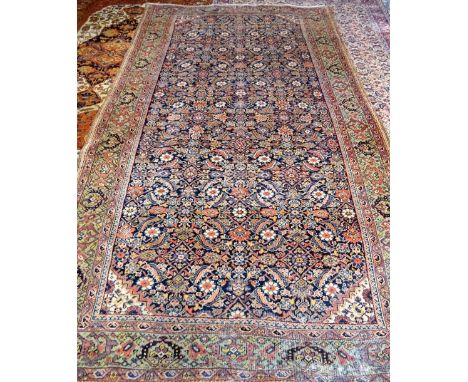 A Fereghan Kelleh carpet, Persian; the dark indigo field with an allover herate design; a sage palmette border, 289cm x 165cm