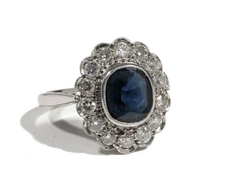 An 18ct gold, sapphire and diamond cluster ring, the central cushion-cut sapphire, collet-set in a white gold mount, with a s