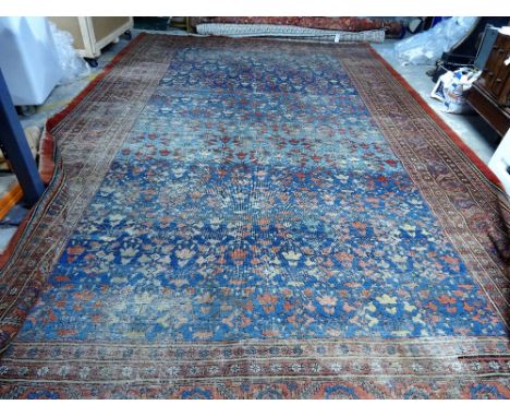 A Tabriz carpet, Persian, the mid indigo blue field with an allover pattern of stylised vases of angular flowers; a madder ro