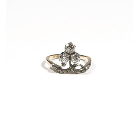 An 18ct gold and diamond-set dress ring of trefoil design, claw-set with old mine-cut diamonds,between diamond set shoulders,