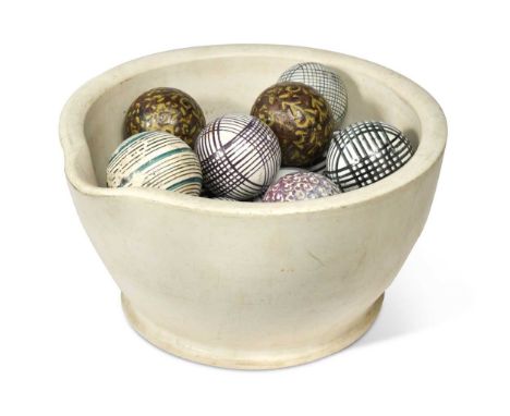 A collection of twelve ceramic carpet bowls contained within a marble mortarthe mortar 35cm diameter