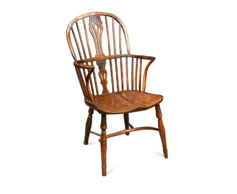 An elm and yew wood Windsor armchair, early 19th century, the turned stick back over a shaped seat on turned legs with crinol