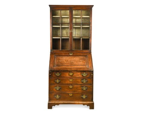 An elm bureau bookcase, 18th century,  the pair of glazed doors above a fielded panel fall front with fitted interior over fo