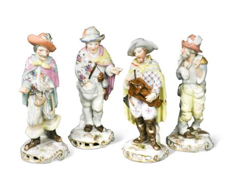 A group of four continental porcelain figurines,  including one playing a hurdy gurdy and another carrying a rabbit16cm high