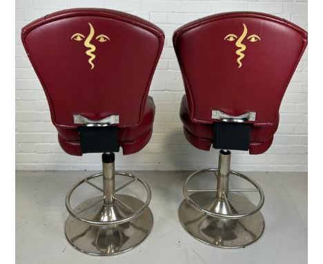 A PAIR OF POKER SWIVEL STOOLS UPHOLSTERED IN RED LEATHER WITH PICASSO STYLE FACES IN YELLOW TO BACKS AND CHROME BASES, 119cm 