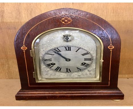 Antique mahogany inlaid mantel clock with silvered dial. Clock complete with pendulum &amp; key. Clock ticks but no warranty 