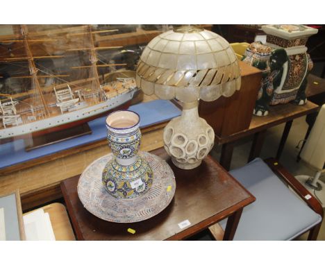 A pottery table lamp and shade, a pottery vase and a wall plate 