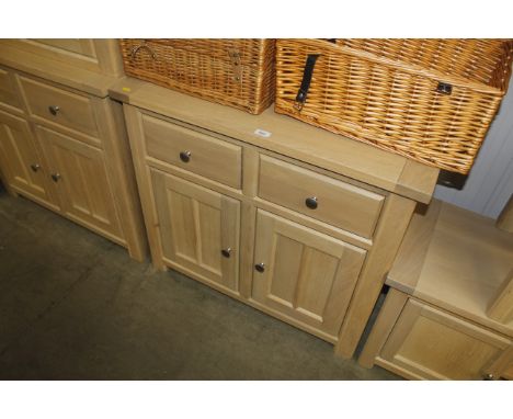 A modern light wood effect sideboard fitted two drawers and cupboards below