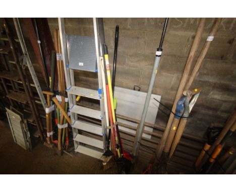 A quantity of long handled tools to include rake, broom etc.