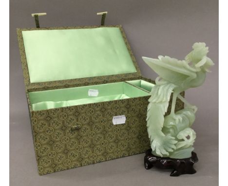 A pale green jade bird, with wooden stand, boxed