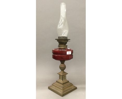A Victorian brass oil lamp with ruby glass reservoir