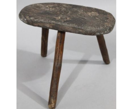 A 19thC scrub top rustic tripod milking stool, 26cm high, 36cm wide, 24cm deep.