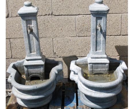 A near matching pair of Grecian style trough fonts, each with rectangular tops and tap fittings above shaped bases, 93cm high