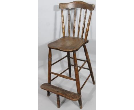 An early 20thC ash and elm child's highchair, with vertical back splat holding a comb top above a shaped seat and foot suppor