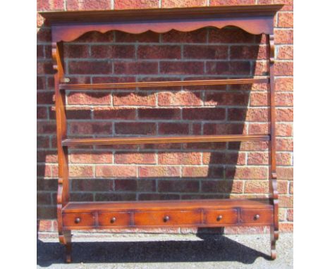 A George III style oak hanging shelf, with overhanging moulded top raised above three delft racks and five various spice draw