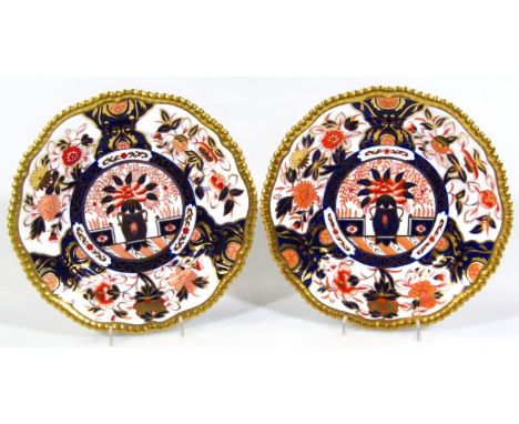 A near matching pair of 20thC Spode Imari pattern plates, each of shaped circular outline with gilt raised borders, of typica