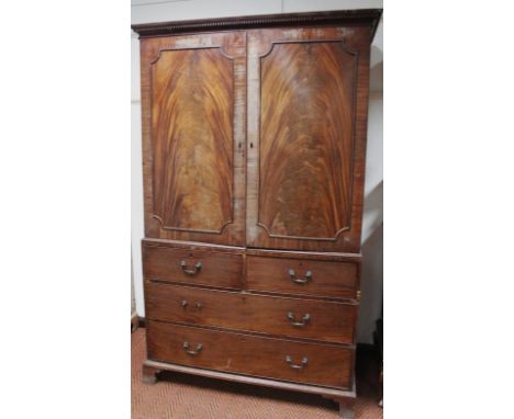 A George III mahogany and flame mahogany linen press, the upper section with a dentil top above two fielded panel doors, hing