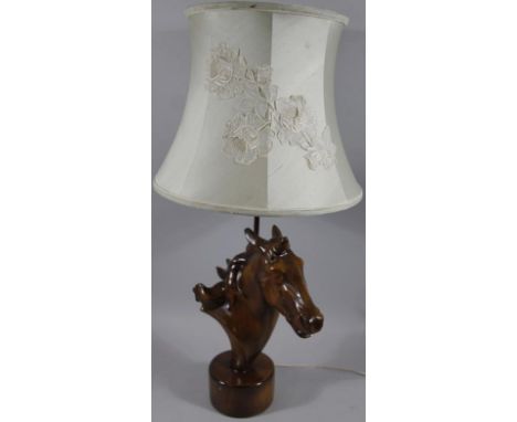 A modern polished hardwood horse head table lamp, the material shade raised with flowers, on a circular foot, 73cm high.
