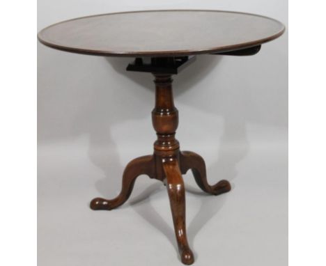 A George III mahogany tripod snap top supper table, the one piece top raised above a bird cage action with baluster support o