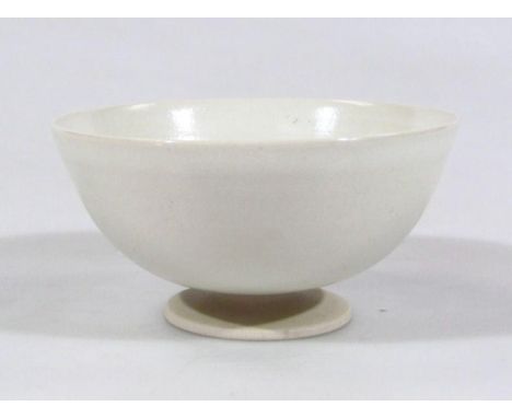 A 20thC Leach style Studio pottery bowl, in cream glazes, on compressed circular foot, wavy line seal mark beneath, 10cm dia.