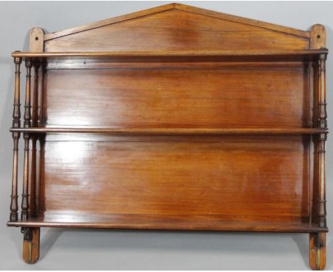 An Edwardian mahogany hanging shelf, with a fixed pediment top, set with three shelves separated by cylindrical supports, 82c