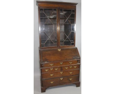 A George III and later oak bureau bookcase, the upper section with an over hanging moulded cornice, above a pair of astragal 