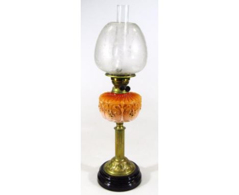 A Victorian orange glass and brass oil lamp, with elaborate part etched shade, clear glass funnel, textured reservoir and flu