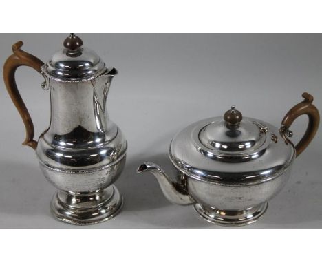 A George V silver two piece part tea service, comprising coffee pot, 24cm high, of elongated bulbous outline with shaped spou