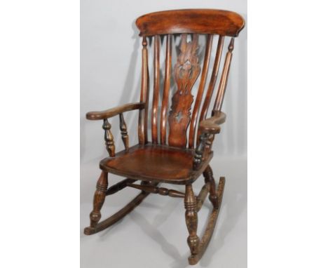 A late 19thC ash and elm grandfather chair, with shaped comb back above pierced splat and heavy arm supports, on ring turned 