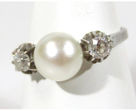 A ladies' pearl ring, flanked by two diamonds, claw set on a part pierced shank, unmarked white metal.