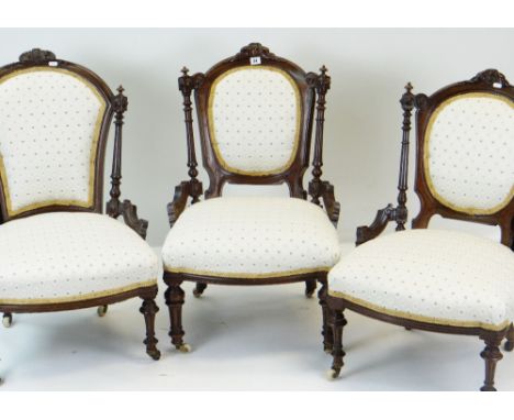 THREE LATE VICTORIAN WALNUT NURSING CHAIRS, similarly upholstered on turned fluted legs with ceramic casters (3)