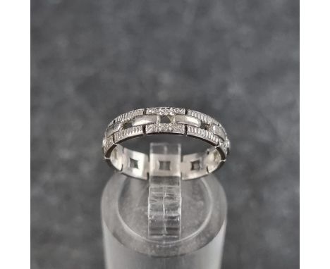 A pierced chain link style ring, stamped Platinum, size K. 