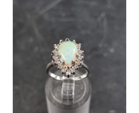 An opal and diamond cluster ring, set tear drop opal surrounded by sixteen small diamonds. 