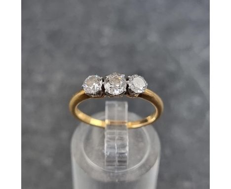 A yellow metal diamond three stone ring, the central stone of approximately 0.15ct, stamped 18ct, size K. 