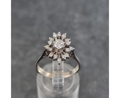 A diamond starburst cluster ring, set central brilliant cut diamond of approximately 0.25ct surrounded by sixteen further dia