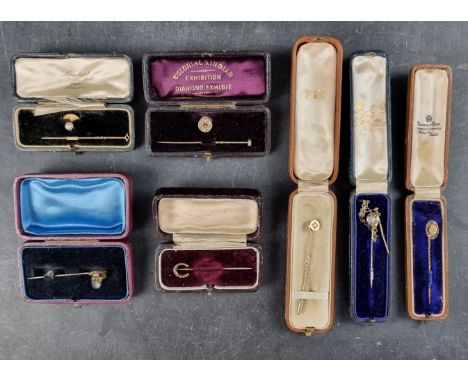 A yellow metal stick pin, set old cut diamond, 6cm; together with another diamond set stick pin; and five others, all cased. 