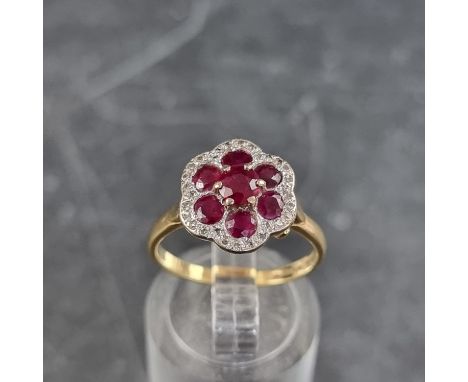 An 18ct gold ruby and diamond floral cluster ring, set seven rubies and multiple small diamonds, size M 1/2, gross weight 3.6