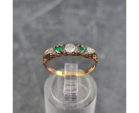 A yellow metal emerald and diamond five stone half hoop ring, size L. 
