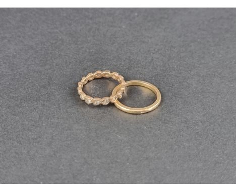 A 9ct gold wedding band, 1.8g; together with and a yellow metal eternity ring, set white sapphires, stamped 9ct. (2) 
