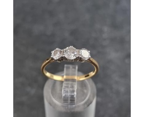 A yellow and white metal diamond three stone ring, the principal stone approximately 0.25ct, size 0 1/2. 