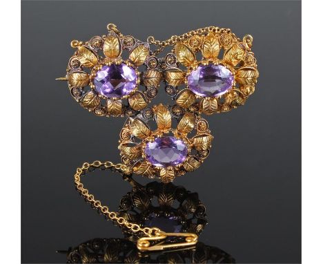 Yellow metal amethyst set brooch, the three amethyst set within curled leaf and flower head mounts, 47mm diameter