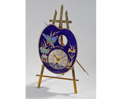 Early 20th Century brass and porcelain easel clock, the dial in the form of an artist pallet, painted with jewelled enamel of