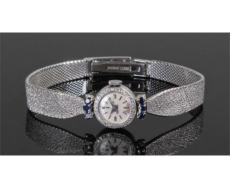 18 carat white gold, sapphire and diamond set ladies wristwatch. The circular case with a diamond set bezel and six sapphires